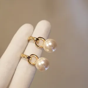 Vista dettagliata di eleganti cerchi d'oro geometrici francesi con perle bianche