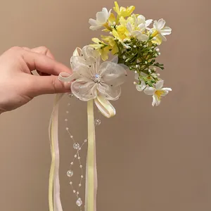 Macro detail of Mori style hair clip featuring yellow flowers and beaded ribbons