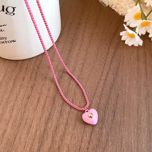 Close-up of a sweet pink resin heart pendant on a matching pink chain necklace