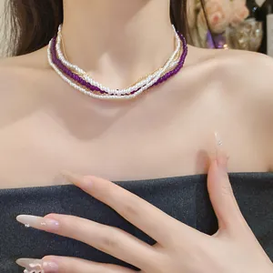 Elegant multi-layered necklace featuring white pearls and purple crystal beads on a model