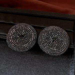 Dettaglio di orecchini a lobo in argento con micro-pavé di strass neri luccicanti