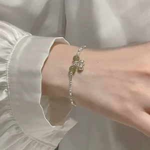 Elegant silver bamboo joint bracelet with green jade beads and tiny bells on wrist