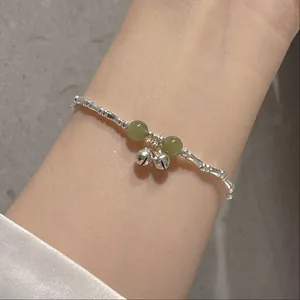 Minimalist silver bamboo joint bracelet with jade-like green beads and small bells