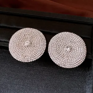 Dettaglio di orecchini a bottone rotondi in argento con pavé di strass brillanti