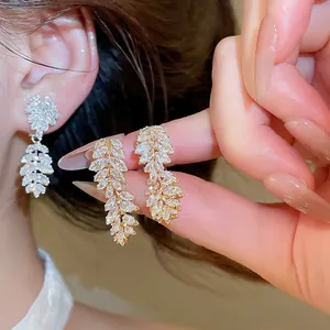 Detailed view of 18k gold-plated zircon leaf ear clips showing sparkle on model