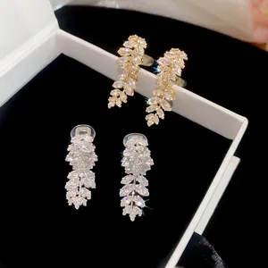 Close-up of 18K gold plated zircon leaf clip earrings in gold and silver finishes
