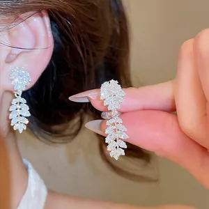 Detailed macro view of sparkling zircon leaf clip-on earrings for non-pierced ears