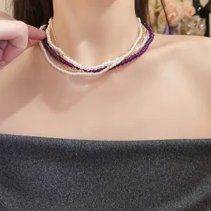 Close-up view of elegant multi-layer necklace featuring white pearls and purple crystal beads