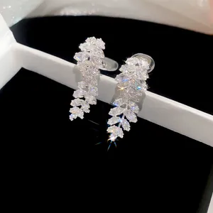 Detailed close-up of sparkling leaf-shaped cubic zirconia ear clips inside a jewelry box