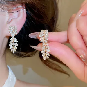 Detail of elegant 18k gold plated leaf ear clips with sparkling cubic zirconia stones.