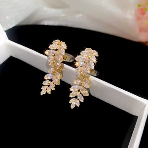 Close-up detail of 18k gold-plated leaf ear clips featuring sparkling marquise zircons