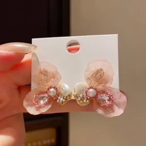 Detailed view of elegant pink resin flower stud earrings with pearls and rhinestones