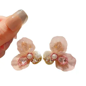 Elegant pink resin flower stud earrings with central pearl and sparkling crystals