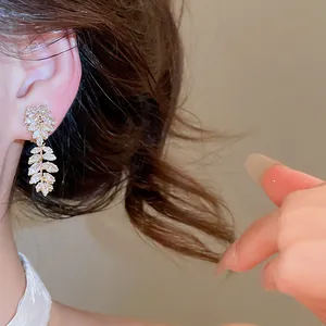 Detail view of 18k gold plated leaf-shaped ear clips with sparkling zircons
