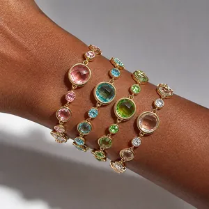 Détail de quatre bracelets en cristal coloré sur le bras d'un mannequin.