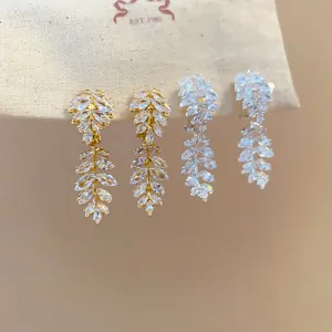 Detailed shot of 18k gold and silver leaf ear clips with sparkling cubic zirconia