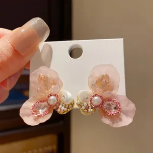 Detailed view of pink resin flower earrings with pearl and rhinestone accents
