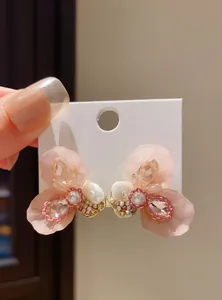 Detail of pink resin flower stud earrings with sparkling crystals and tiny pearls