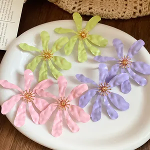 Macro view of oversized flower earrings in vibrant pastel pink, purple and lime green