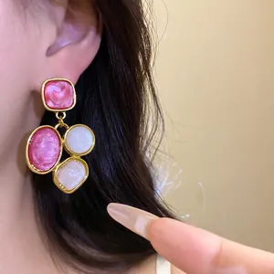 Eleganti orecchini pendenti vintage in resina dorata nei toni rosa e bianco per donna