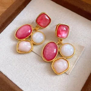 Orecchini vintage placcati oro con pietre in resina rosa e bianca, stile elegante.
