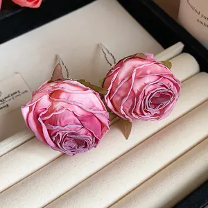 Primo piano di forcine per capelli a rosa in tessuto rosa con trame di petali delicate