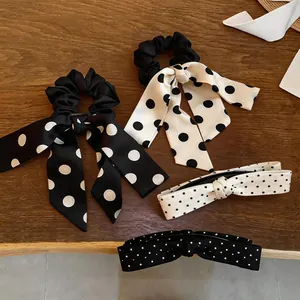Detail showing elegant black and white polka dot satin scrunchies and hair clips on wood