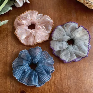 Detail view of three colorful chiffon scrunchies with polka dot and checkered patterns