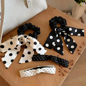 Detail of French style satin polka dot bow scrunchies and hairbands on a wooden table