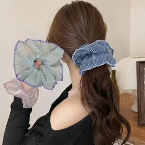 Close-up detail of colorful chiffon polka dot and plaid scrunchies with lace ruffles.