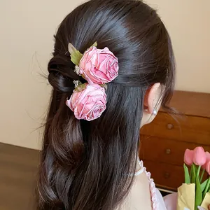Primo piano dettagliato di forcine per capelli con rose in tessuto rosa acconciate