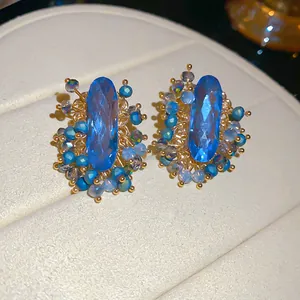 Detailed close-up of vintage blue oval crystal earrings with intricate beadwork