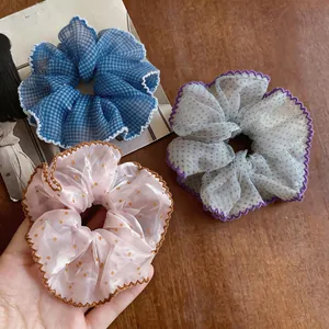 Close-up detail of stylish chiffon polka dot ruffled scrunchies with elegant scalloped lace edges