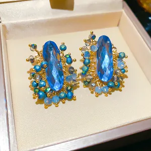 Close-up of vintage palace style oval blue crystal earrings with bead detailing