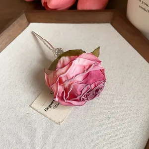 Vista dettagliata di un fermaglio per capelli a rosa di stoffa rosa fatto a mano