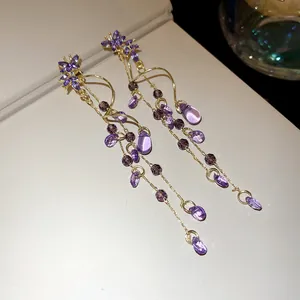 Detail view of purple butterfly crystal earrings with long teardrop tassel beads