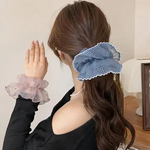 Detail of blue gingham and pink polka dot chiffon hair scrunchies on hair and wrist.