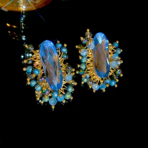 Vintage court style earrings with large oval blue crystals and intricate gold wire wrap