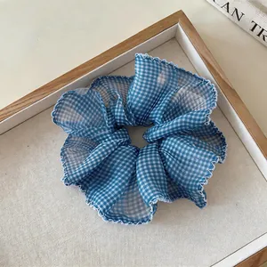 Detailed view of blue and white gingham ruffled chiffon scrunchie with lace trim