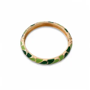 Elegant gold-tone bangle featuring two-tone green wavy enamel patterns with a secure clasp