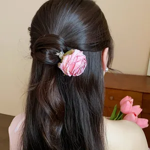 Vista dettagliata di un'elegante forcina per capelli a rosa in tessuto rosa seta