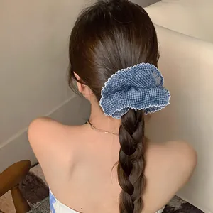 Detail of blue gingham chiffon scrunchie with white lace trim on ponytail