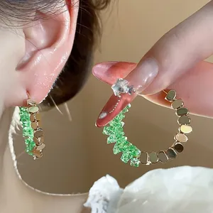 Exquisite 14K gold plated hoop earrings featuring vibrant green crushed crystal accents