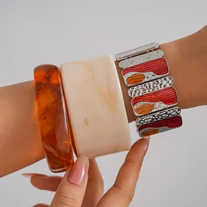 Close-up of bohemian resin bangles and dripping oil metal elastic bracelet set