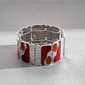 Detail of vintage red enamel metal elastic bracelet with hammered silver texture