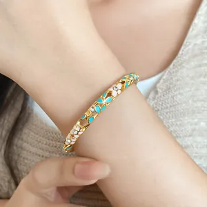 Close-up detail of gold floral buckle bracelet with blue and pink enamel and crystals