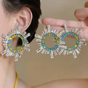 Dettaglio orecchini vintage geometrici con strass colorati e cristalli a raggiera