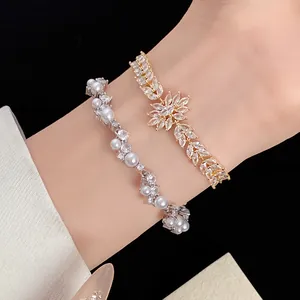 Macro detail of elegant gold wheat-leaf zircon bracelet and silver pearl wavy jewelry
