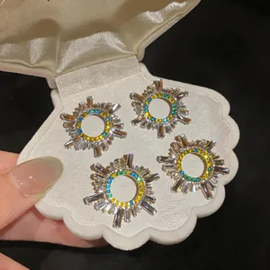 Dettaglio di orecchini vintage con strass in un portagioie a forma di conchiglia bianca