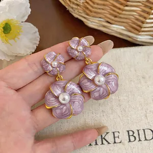 Detailaufnahme violetter Emaille-Blumenohrringe mit Perle im Vintage-Stil